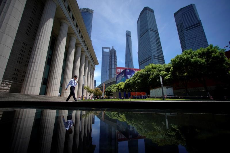 © Reuters. A man walks at Lujiazui financial district of Pudong in Shanghai