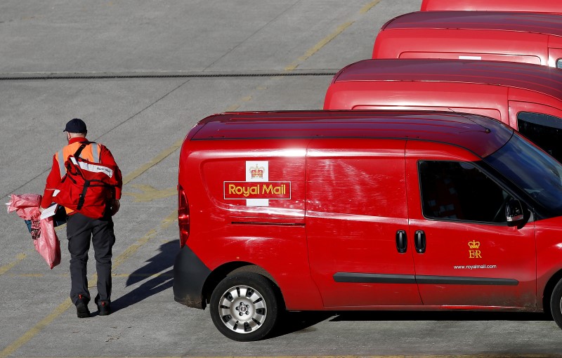 © Reuters. File Photo: A postal worker carries mail bags from a van at a Royal Mail sorting office in Altrincham northern England.