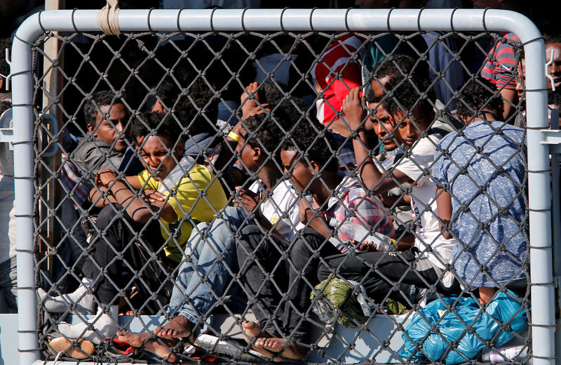 © Reuters. FILE PHOTO: Migrants wait to disembark from German vessel FGS Rhein in the Sicilian harbour of Catania