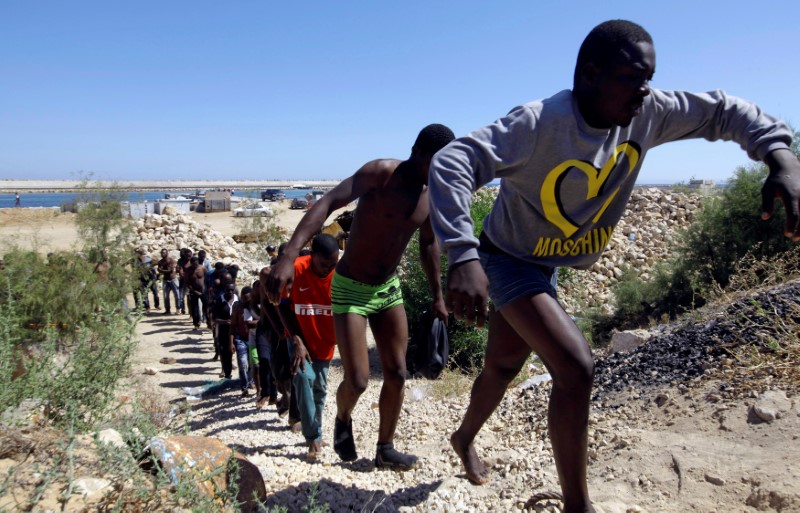 © Reuters. FILE PHOTO - Migrants walk after they were rescued by Libyan coastguard at the coast of Gharaboli, east of Tripoli