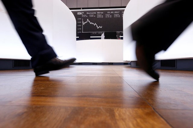 © Reuters. FILE PHOTO: A trader walks past the German DAX Index board on the trading floor at the Frankfurt stock exchange in Frankfurt