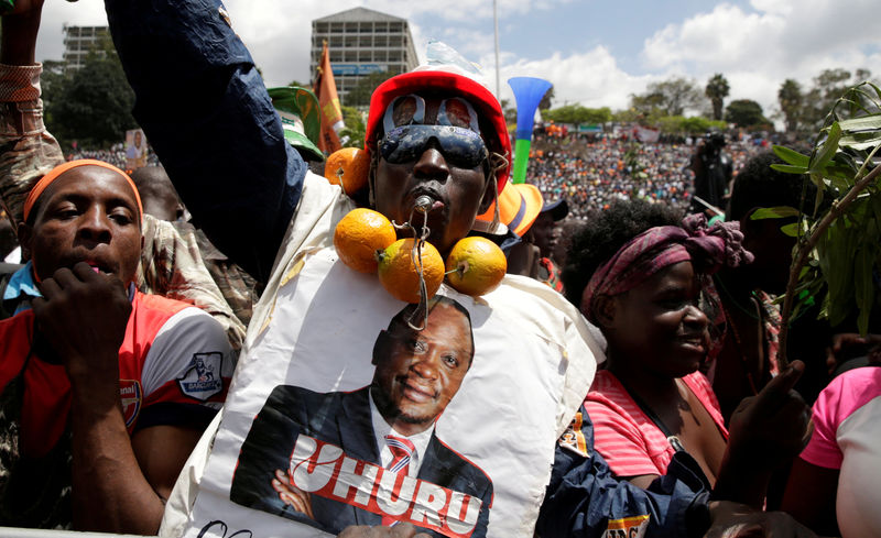 © Reuters. FILE PHOTO: A supporter of Kenyan opposition NASA coalition wears a poster decipting Kenya's President Uhuru Kenyatta at a rally endorsing Raila Odinga as the presidential candidate for the 2017 general elections at the Uhuru Park grounds, in Nairobi