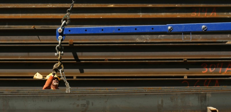 © Reuters. A worker guides a steel beam into place at a construction site in San Francisco