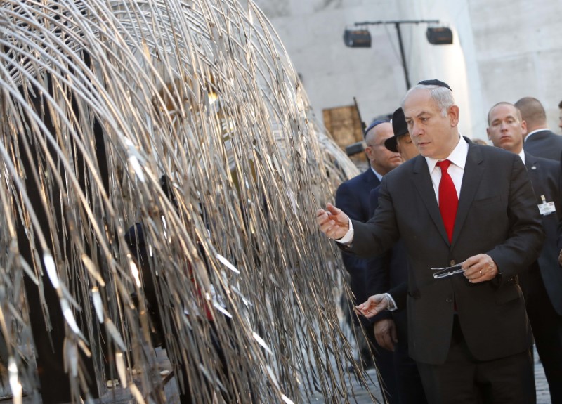 © Reuters. Israel's Prime Minister Netanyahu pays tribute to the memory of victims of the Holocaust at a memorial in the main synagogue in Budapest