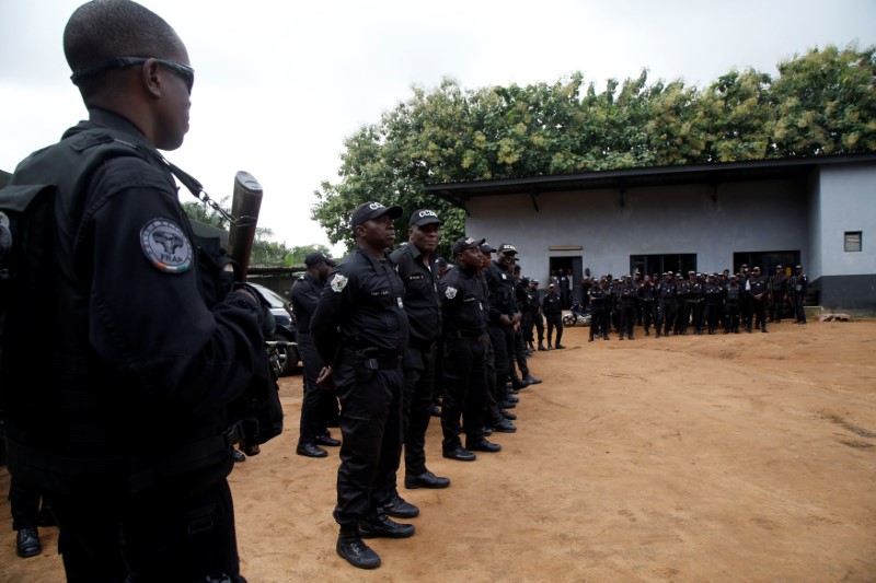 © Reuters. Police officers carry their weapons as they stand on the premises of the National Police Academy in the Cocody neighborhood in Abidjan