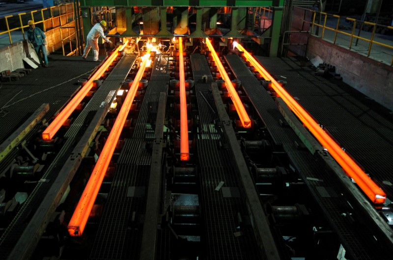 © Reuters. FILE PHOTO: Employees work at a workshop of Hangzhou Iron and Steel Group Company in Hangzhou