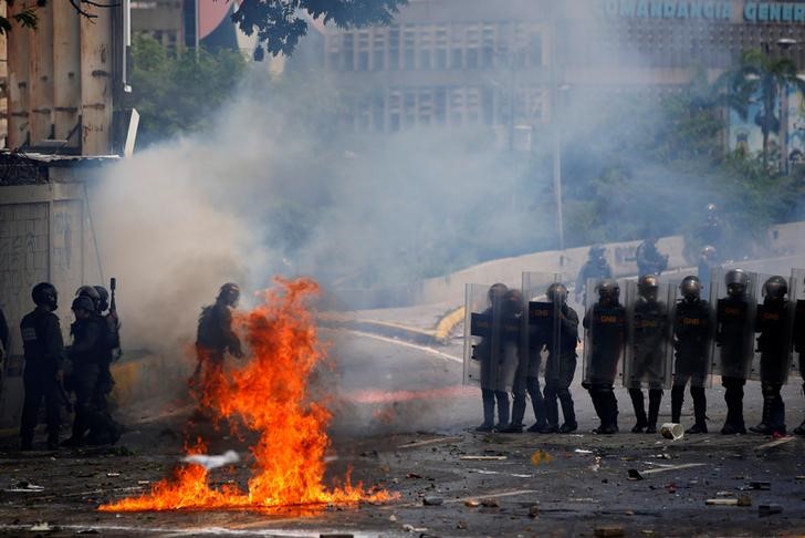 © Reuters. Forças de segurança se movimentam durante confronto com manifestantes em Caracas