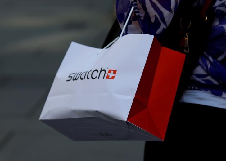 © Reuters. A women carries a shopping bag of Swiss watchmaker Swatch in Vienna