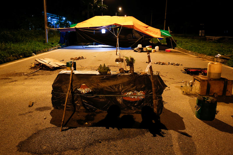© Reuters. A coffin and petrol bottles are seen near protesting camp sets by villagers to block entrance of Hong Kong's Pacific Crystal textiles factory after villagers accused the company of polluting local water in Hai Duong province, outside Hanoi