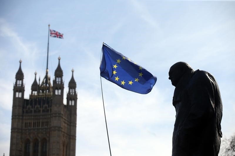 © Reuters. FILE PHOTO: An EU flag flies between the statue of Winston Churchill and a Union Flag flying from the Big Ben clock tower, during a Unite for Europe rally in Parliament Square, in central London