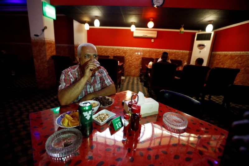 © Reuters. People have drinks at a bar in the town of Qaraqosh