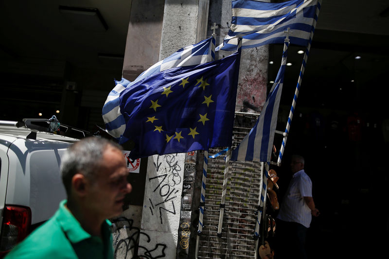 © Reuters. Greek national flags and a European Union flag flutter outside a shop in central Athens
