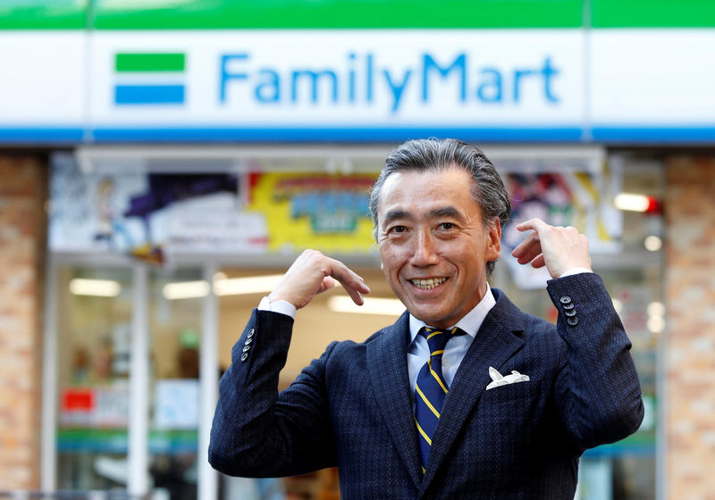 © Reuters. FamilyMart Co's President Sawada poses for a photo in front of a FamilyMart convenience store after an interview with Reuters in Tokyo