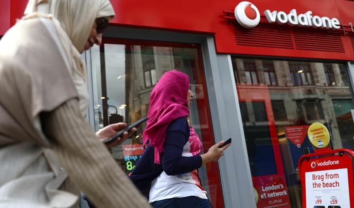 © Reuters. Mulheres usam celulares em frente a loja da Vodafone em Londres, Reino Unido