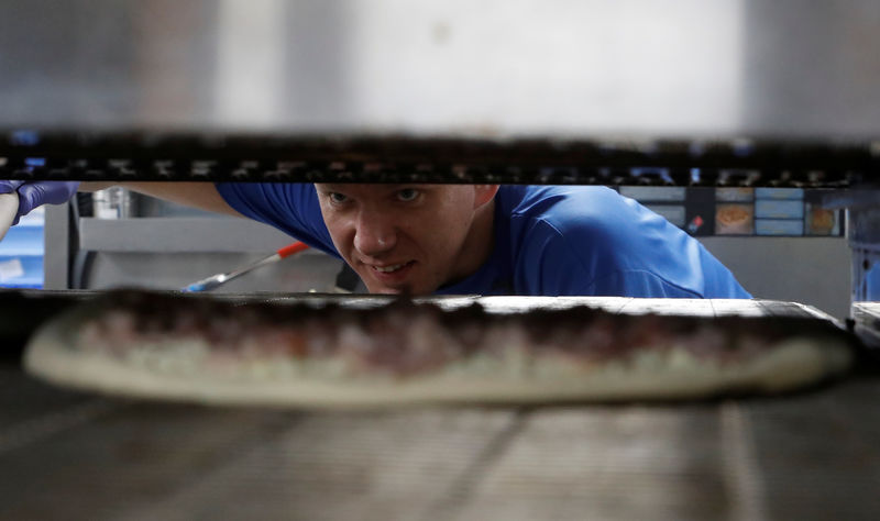 © Reuters. A staff member prepares a pizza at a Domino's Pizza restaurant in Moscow