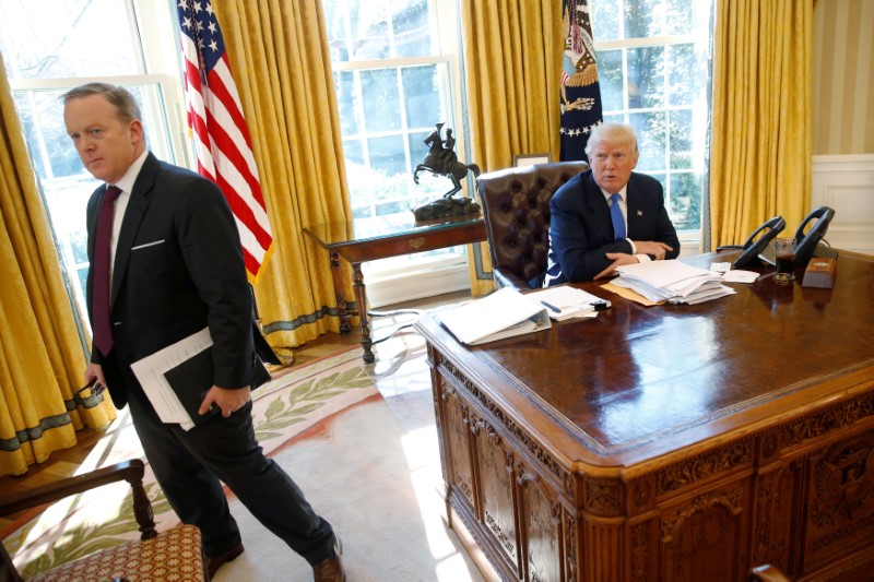 © Reuters. FILE PHOTO: White House Communications Director Spicer stands with President Trump at conclusion of Reuters interview at the White House in Washington