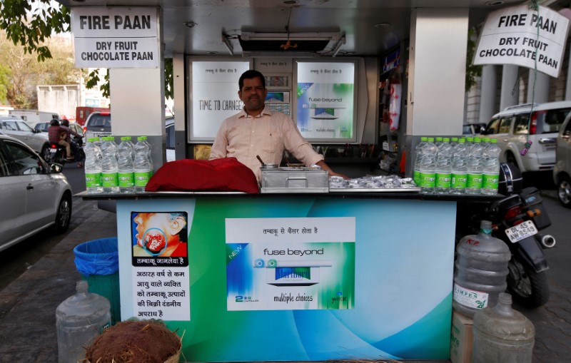 © Reuters. A vendor looks on as Marlboro advertisements are seen in his stall in a marketplace in New Delhi