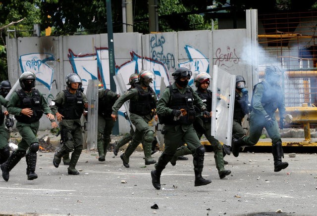 © Reuters. Riot security forces take position while clashing with demonstrators rallying against Venezuela's President Nicolas Maduro's government in Caracas