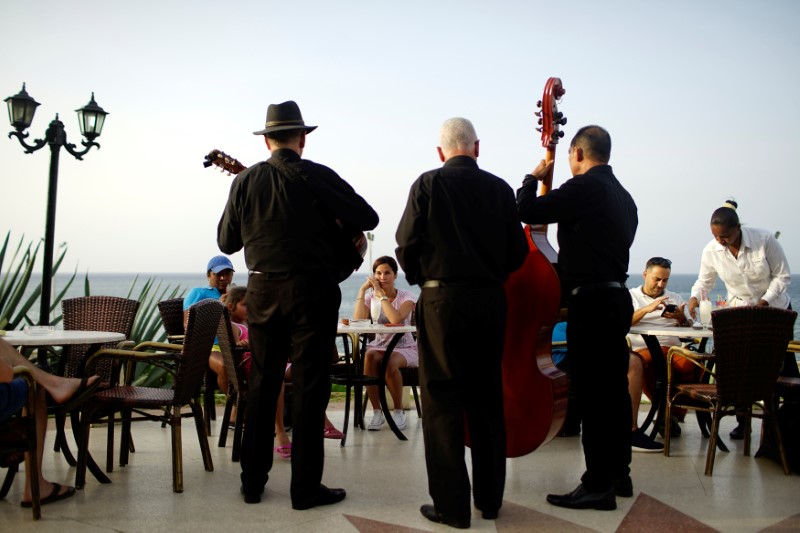 © Reuters. Tourists enjoy live music at a hotel in front of the seafront Malecon in Havana