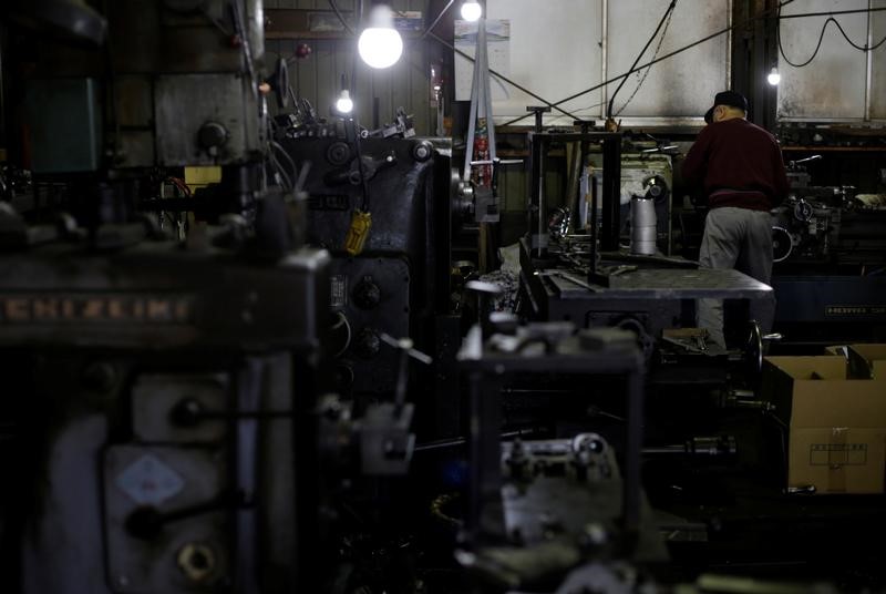 © Reuters. A man works at a factory that manufactures iron pipe fittings in the Keihin industrial zone in Kawasaki