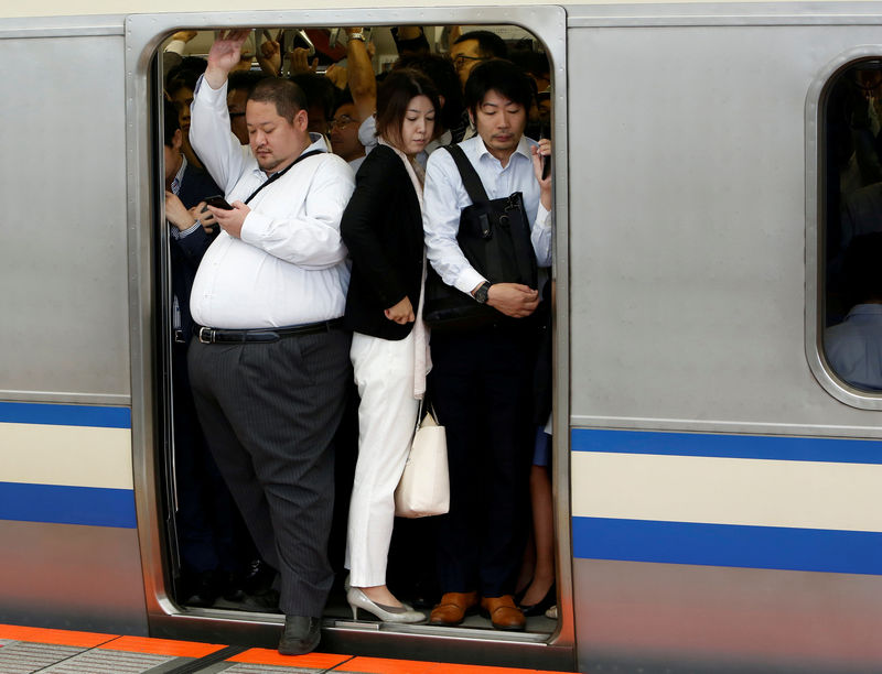 © Reuters. FILE PHOTO: Passengers ride an overcrowded train at a station in Kawasaki