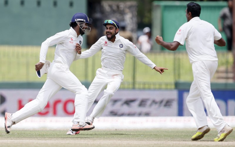 © Reuters. India's Rahul celebrates with captain Kohli and Ashwin after taking the catch to dismiss Sri Lanka's Thirimanne during the final day of their third and final test cricket match  in Colombo