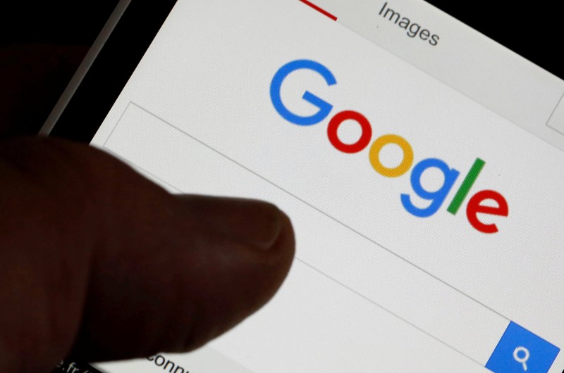 © Reuters. FILE PHOTO: A man holds his smartphone which displays the Google home page, in this picture illustration taken in Bordeaux