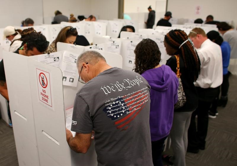 © Reuters. FILE PHOTO: A voter wears a shirt with words from the United States Constitution while casting his ballot early as long lines of voters vote at the San Diego County Elections Office in San Diego, California