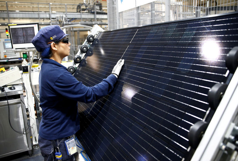 © Reuters. FILE PHOTO: An employee makes a final inspection on panels during a tour of an REC solar panel manufacturing plant in Singapore