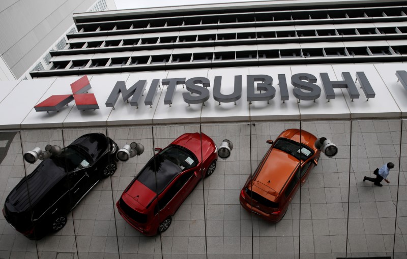 © Reuters. Автомобили Mitsubishi Motors Corp отражаются в стене здания компании в Токио