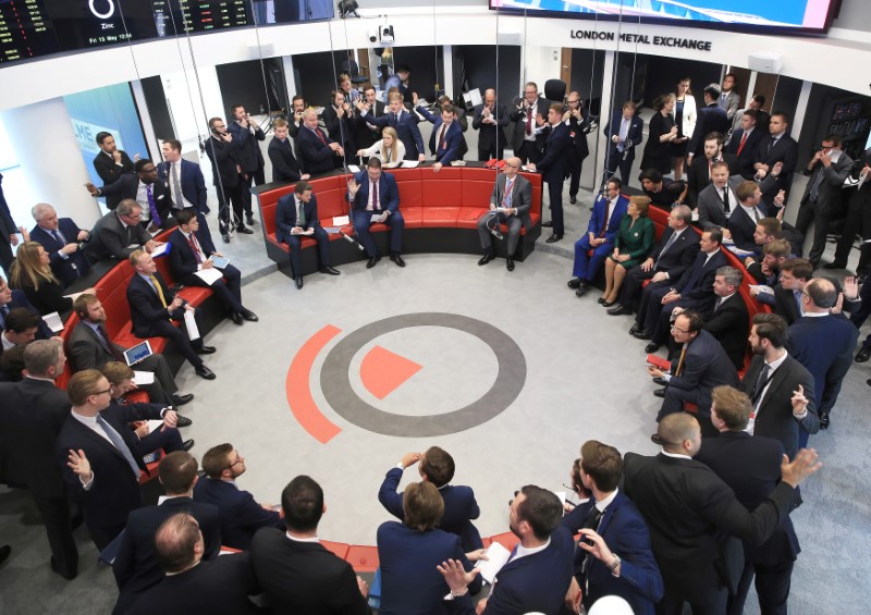 © Reuters. Chilean President Michelle Bachelet (green dress) watches trading with Peter Childs (L), head of price discovery at London Metal Exchange and CEO Garry Jones (R), after officially opening the London Metal Exchange, London