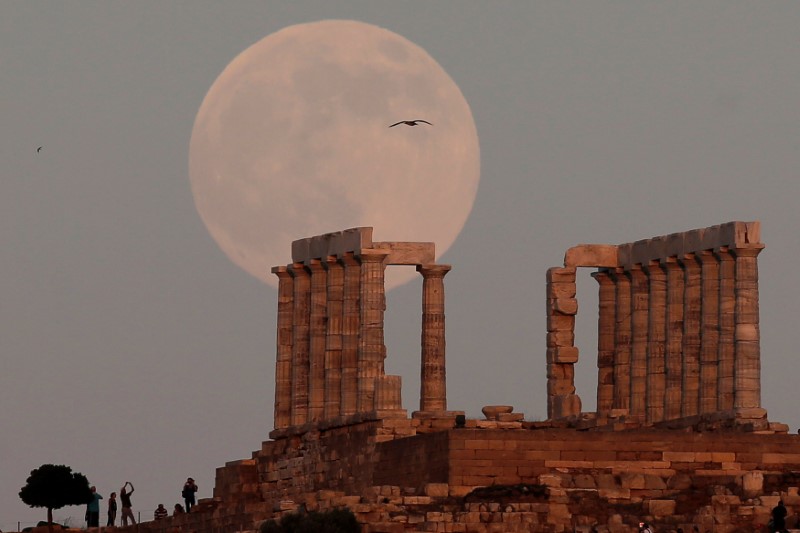 © Reuters. FILE PHOTO: A nearly full moon rises over the Temple of Poseidon, the ancient Greek god of the seas, in Cape Sounion, east of Athens