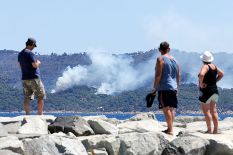 © Reuters. Turistas observam fumaça de incêndios florestais em La Croix-Valmer, na França