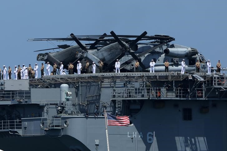 © Reuters. U.S. Marines and sailors man the rails aboard the USS America (LHA-6) as they leave port and deploy to the Pacific with the America Amphibious Ready Group from Naval Base San Diego