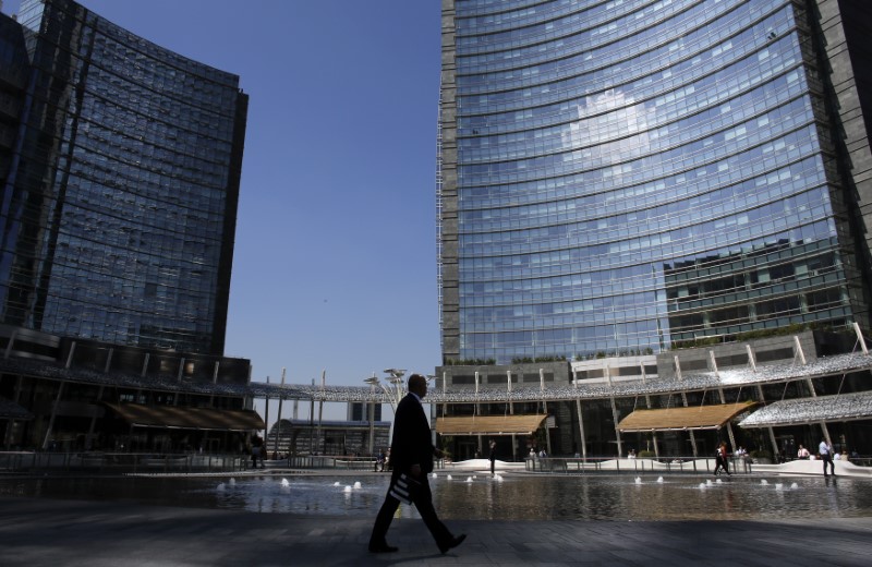 © Reuters. Milano, passeggiando davanti alla sede di UniCredit