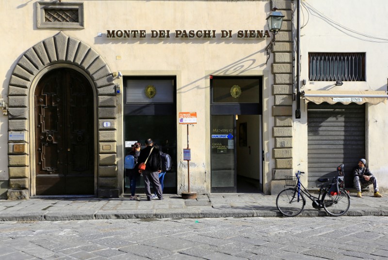 © Reuters. FILE PHOTO: People use a cash machine of Monte Dei Paschi bank in Florence