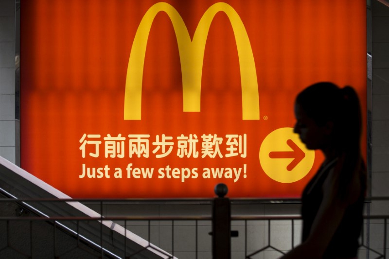 © Reuters. FILE PHOTO - A woman walking past a McDonald's outlet in Hong Kong