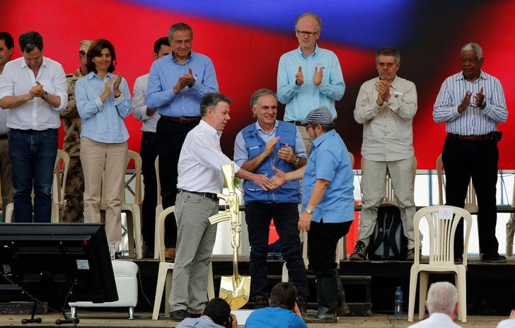 © Reuters. Presidente colombiano, Juan Manuel Santos (à esquerda), e o líder das Farc, Rodrigo Londono, se cumprimentam na cerimônia final de entrega das armas pelos rebeldes