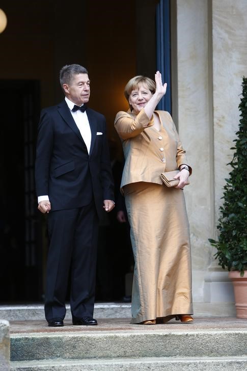 © Reuters. Chanceler alemã, Angela Merkel, e seu marido, Joachim Sauer, posam para fotos ao chegarem a festival de ópera em Bayreuth