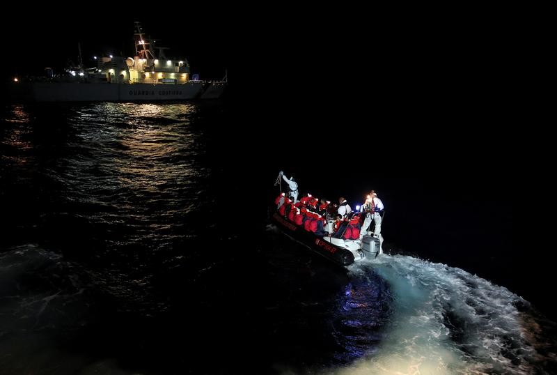 © Reuters. FILE PHOTO: Fiorillo" Italian Coast Guard vessel officers transfer migrants being rescued by "Save the Children" NGO crew from the ship Vos Hestia, in the Mediterranean sea off the Libyan coast