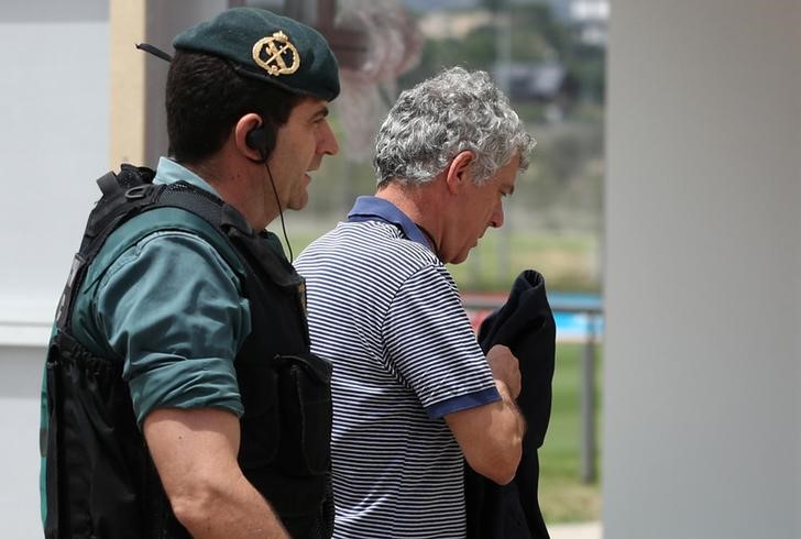© Reuters. El presidente de la Federación Española de Fútbol (RFEF) es acompañado por la Guardia Civil durante un allanamiento a la sede de la federación en Las Rozas