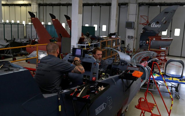 © Reuters. Workers conduct maintenance work to a fighter plane in a hangar of an aircraft manufacturer Aero Vodochody near the town of Odolena Voda