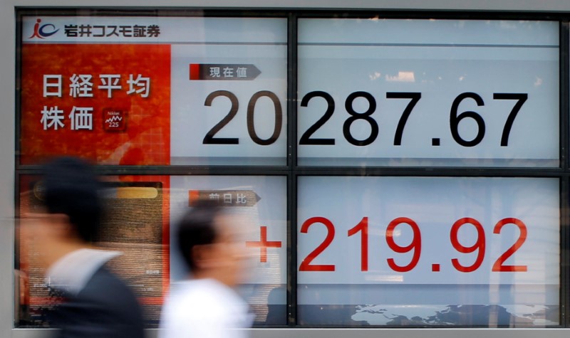 © Reuters. Tokyo, il tabellone elettronico di un brokerage con l'andamento della borsa