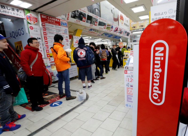 © Reuters. FILE PHOTO: People line up to get their hands on the Nintendo Switch game console at an electronics store in Tokyo