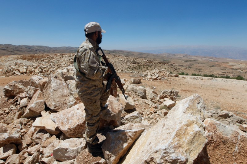 © Reuters. A Hezbollah fighter holds his weapon in Juroud Arsal, Syria-Lebanon border