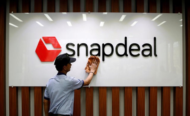 © Reuters. FILE PHOTO: An employee cleans a Snapdeal logo at its headquarters in Gurugram