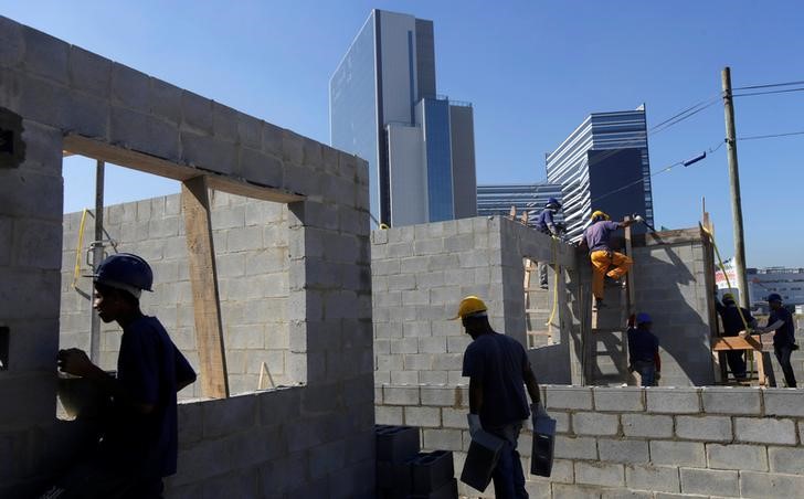 © Reuters. Homens trabalham na contrução de casas, no Rio de Janeiro