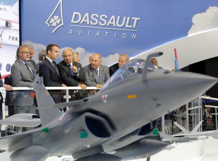 © Reuters. French President Macron listens to Dassault Aviation CEO Trappier as Serge Dassault, Chairman and CEO of Dassault Group, looks on during a visit at the Paris Air Show in Le Bourget