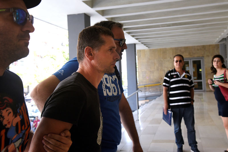 © Reuters. Alexander Vinnik, a 38 year old Russian man suspected of running a money laundering operation, is escorted by plain-clothes police officers to a court in Thessaloniki