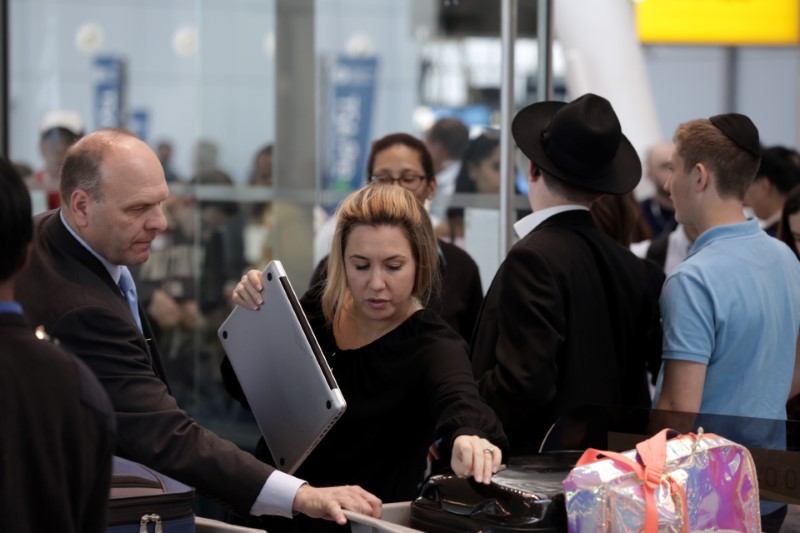 © Reuters. FILE PHOTO: A traveler takes her laptop out of her bag for scanning at Terminal 4 of JFK airport in New York City